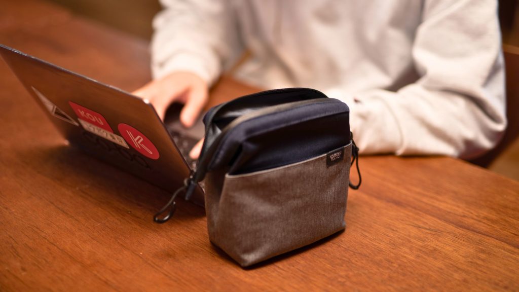 カフェでノートパソコン作業をするノマドワーカーの横で自立するデイズポーチ